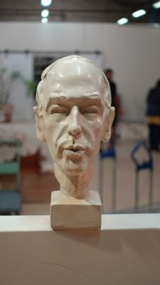 a sculpture of a man ' s face on display in a museum