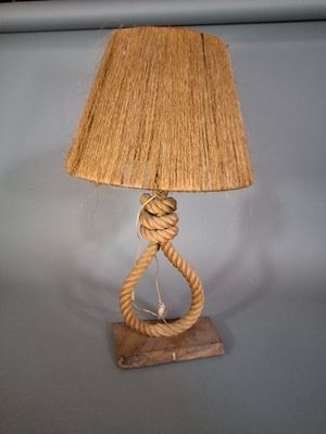 une lampe entourée d'une corde, posée sur une table