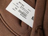 a label on the back of a brown sweater