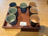six tasses posées sur un plateau, avec une étiquette de prix dessus