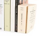several books are stacked on top of each other on a shelf