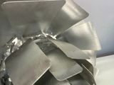 a close up of a metal propeller on a white surface