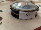 a small clock on a table with a price tag on it