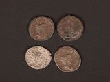 four different types of coins on a black surface
