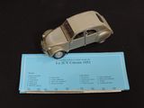 a silver toy car on top of a blue business card