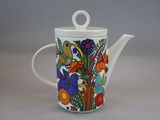 une théière blanche ornée d'un motif floral coloré
