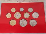 deux livrets rouges ornés de pièces d'argent, posés sur une surface blanche