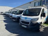 de nombreuses camionnettes blanches garées en rangée sur un parking