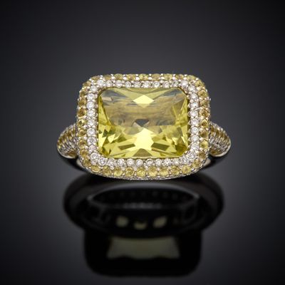 a yellow sapphire and diamond ring on a black surface