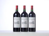 three bottles of red wine are lined up on a table