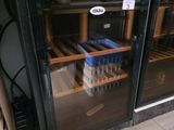 une porte vitrée derrière laquelle se trouvent tout un tas de bouteilles