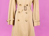 un trench-coat beige sur un mannequin, un mannequin, un mannequin, un mannequin, un mannequin, un mannequin, un mannequin, un mannequin, un manne