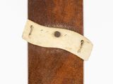 a piece of leather with a piece of wood sticking out of it