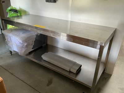 une table de travail en acier inoxydable sur laquelle se trouve un rouleau de papier