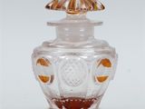 a glass jar with a lid that has an orange design on it