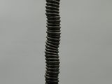 a tall metal object with a spiral design on top of it