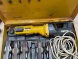 une boîte à outils jaune contenant des outils, posée sur une table