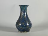 un vase bleu posé sur une surface blanche