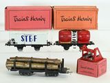 two toy trains and a boxcar on a white surface