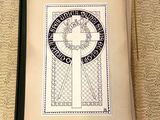 un livre ouvert, marqué d'une croix, posé sur une table