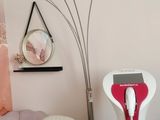 a picture of a living room with a white chair and a red and white floor lamp