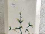 a white vase with a plant on it on a table