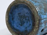 a close up of a blue vase on a white surface
