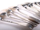 six spoons are lined up in a row on a white surface