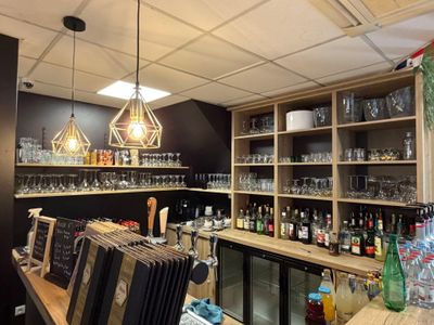 un bar avec plein de bouteilles et de verres sur les étagères