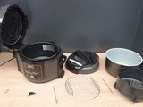 a crock pot, a frying pan, a frying pan, a frying pan, and a frying pan on a table