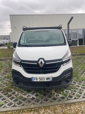 l'avant d'une camionnette blanche garée devant un immeuble