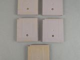 four white light switch covers on a gray wall