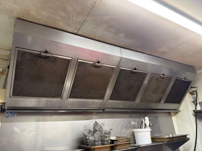a large stainless steel kitchen with a range hood
