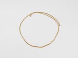 un bracelet en or avec une fine chaîne sur fond blanc