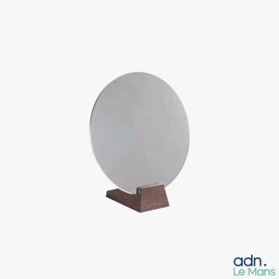 an image of a round mirror on a wooden stand