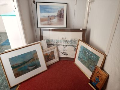 un tapis rouge posé au sol devant un mur orné de tableaux