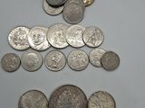 some silver coins and a chain are on a white surface