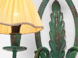 a green wall light with a yellow shade on it