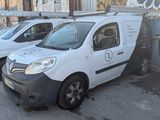 plusieurs fourgonnettes blanches garées sur un parking à côté d'un immeuble