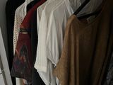 a lot of clothes hanging on a rack in a closet