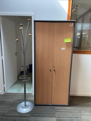 a coat rack in the corner of a room next to a door