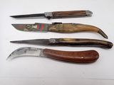 several knives are lined up on a white surface with a wooden handle