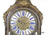 a gold clock with blue and white roman numerals on the face