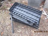 a black crate sitting on the ground next to a chair