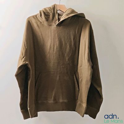 a brown hoodie hanging on a hanger against a white wall