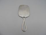 a silver spatula with a handle on a white surface