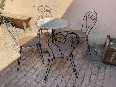 three chairs and a table on a brick patio