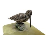 statue of a bird sitting on a rock with a white background