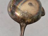 a silver spoon with a bird on it sitting on a table