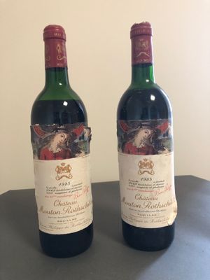 deux bouteilles de vin posées sur une table l'une à côté de l'autre